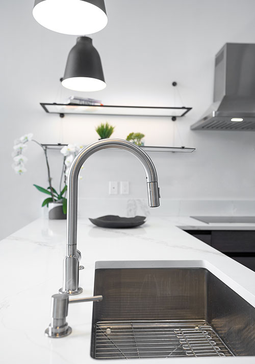 Singletree townhome remodel - kitchen faucet detail and white slab countertop