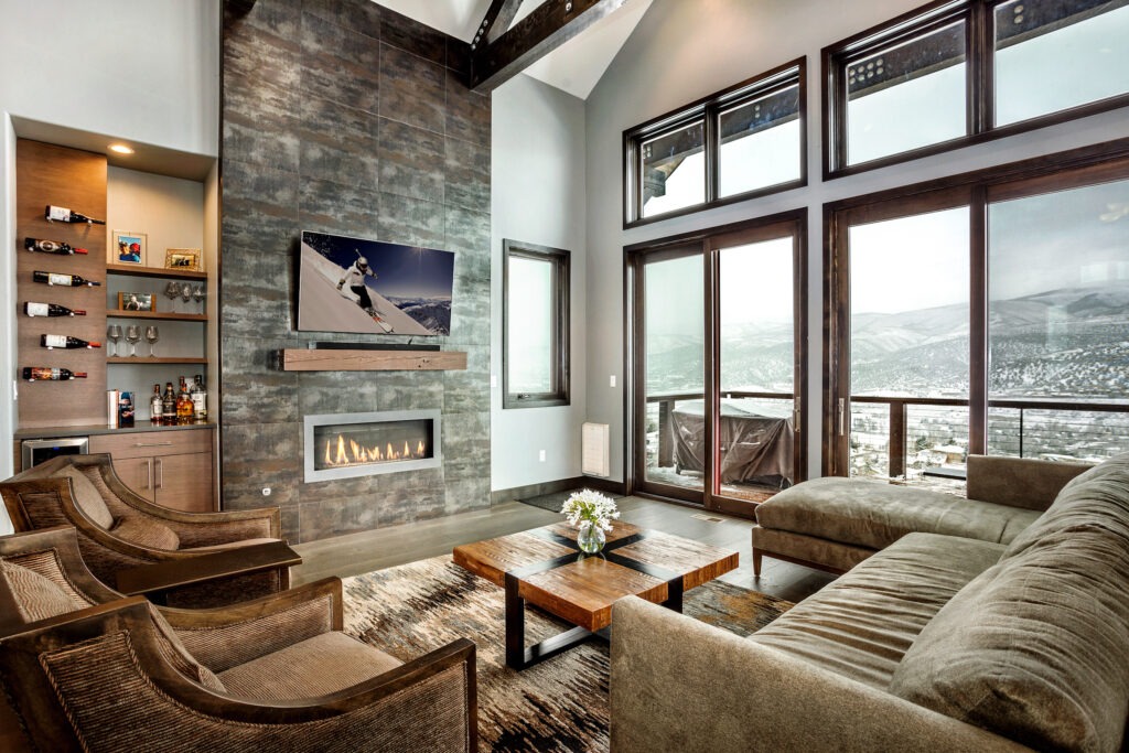 Mountain retreat home with inviting living room and floor-to-ceiling porcelain tiled fireplace with landscape unit.